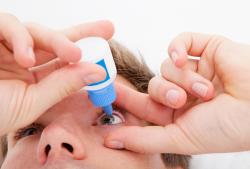 man putting in contact solution on his lenses